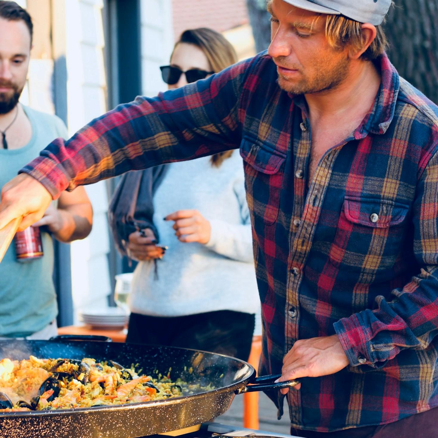 Diverse group of community members sharing a meal together, showcasing the social bonds formed through collaborative cooking
